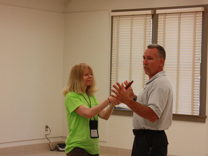 An instructor and a student practising a calm, open-hand stance in a community class